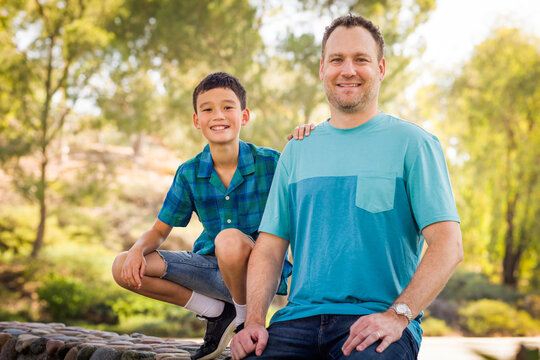 Outdoor portrait of mixed race Chinese and Caucasian father and son.