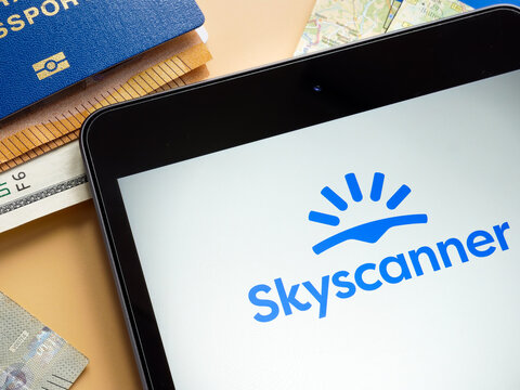 KYIV, UKRAINE - July 21, 2022. Skyscanner logo, passport and money.