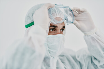 Covid, pandemic and healthcare worker wearing protective ppe to prevent virus spread at a quarantine site or hospital. Closeup of a doctor or scientist wearing a hazmat suit and goggles for safety
