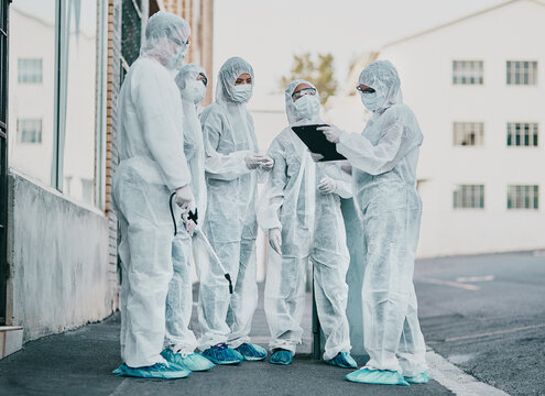 Covid, pandemic and healthcare team wearing protective ppe to prevent virus spread at a quarantine site. First responders wearing hazmat suits while discussing plan for cleaning and disinfecting