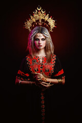 Pretty young ethnic woman wearing gold crown and dreadlocks