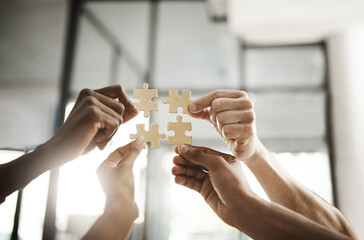 Business people hands with puzzle showing solution, problem solving and teamwork. Smart group or team activity completing, finishing a task project or assignment in difficult challenging work crisis - obrazy, fototapety, plakaty