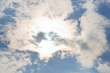 bright sun against the blue sky and clouds