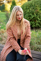 Obraz premium beautiful blonde young smiling girl walking in autumn park 