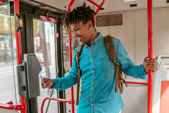 Guy holding card to reader on bus
