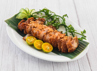 Crispy Bagnet with lime served in dish isolated on grey wooden background side view of fastfood