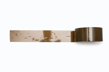 A roll of brown duct tape is unwound and stuck to a white background with bumps. A stationery item in the form of adhesive tape for gluing paper or for a delivery service