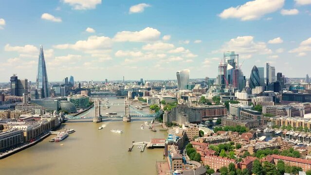 Aerial backwards footage of Tower bridge, Shard and City of London on a sunny day.