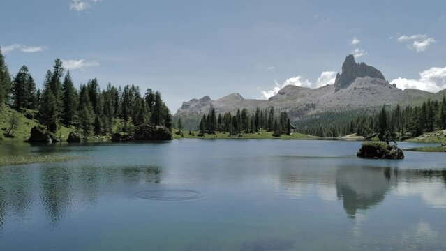 Stone being thrown in the water in the lake Croda da Lago