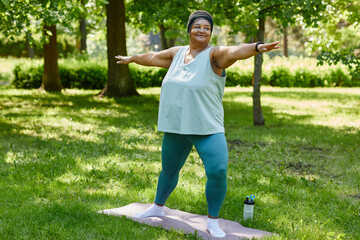 Full length portrait of overweight black woman working out outdoors in park and smiling, copy space - obrazy, fototapety, plakaty