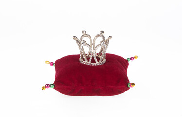 crown on red pillow isolated on white background