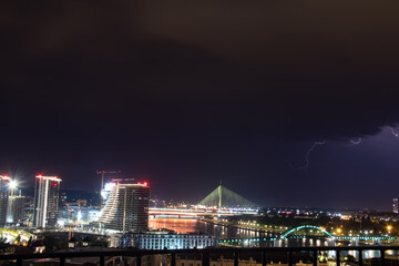 Obraz premium Very cloudy sky, lightning and thunder above the Belgrade sky, panoramic view of the city and the river with bridges. Belgrade is the capital of the Republic of Serbia