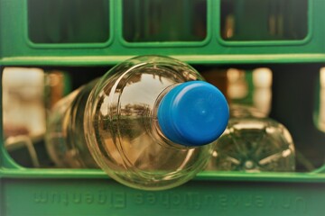Wasserflasche guckt aus grüner Getränkekiste aus Plastik 