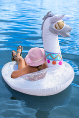 Mädchen mit Hut im Schwimmring auf dem Meer