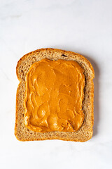 Slice of open sandwiche from wholegrain bread with peanut butter, healthy snack option