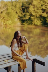 A hippie woman outdoors by the lake having fun in the fall