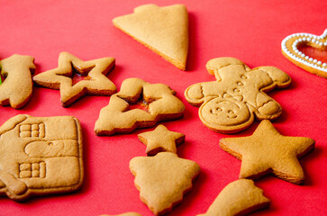 Empty gingerbread cookies ready to be decorated with icing sugar on a red background