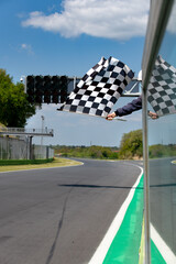 Checkered flag waving on asphalt track finish race competition concept