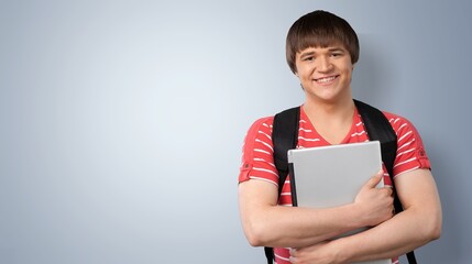 Male student with backpack on light background