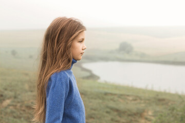 girl in a foggy morning near the lake