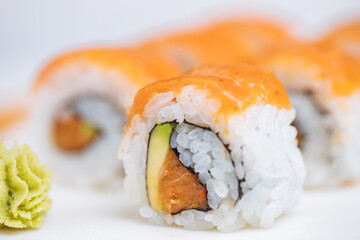 Sushi rolls on platter, bright background. Served with wasabi and ginger. Assorted Japanese sushi. Traditional food. 