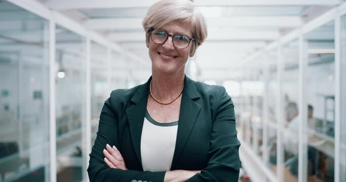 Portrait of a proud, happy business woman leading with confidence while standing in a modern office. Leader standing with arms crossed looking ambitious, enjoying career, satisfied with corporate job