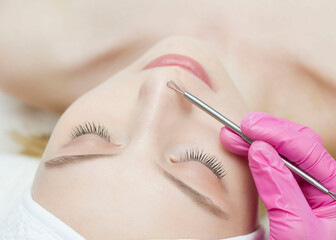 Procedure for cleaning skin with steel tool from blackheads and acne. Deep cleansing of the female face with blackhead remover in the beauty salon. Cosmetologist making receiving cleansing therapy