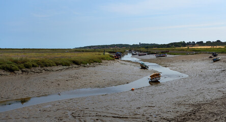 Tidal creek between Blakeney and Morston Quay at low tide with boats