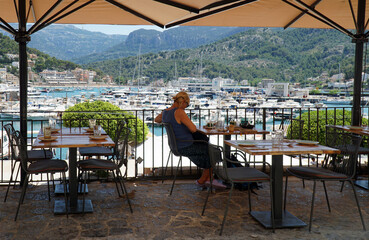 Harbour side restaurant with boat and marina in background.