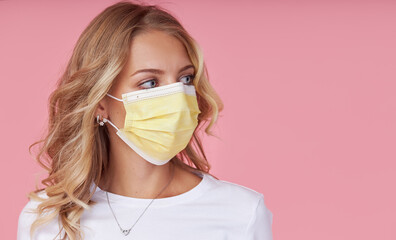 A young attractive woman in a white casual t-shirt wears a protective face mask. Protection against...