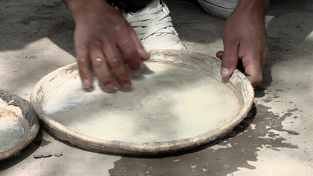 Hands of an Argentine Drum Maker During the Hydration Process of a Membrane of an Argentine Drum Called "Bombo Leguero" at his Workshop. Close Up.