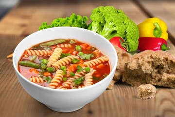 Bowl with tasty soup on wooden background