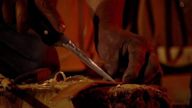 Man Cutting Leather Straps While Making A Bombo Leguero Drum made with Wood and Animal Leather, Used in Argentine Folk Music. Close up. 