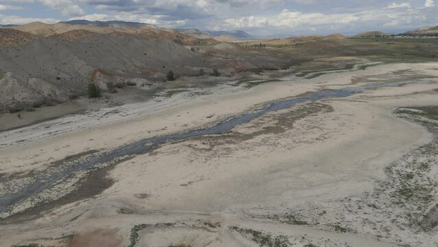 Aerial-Descending-Reservoir reduced to trickle of water that once was a river through an otherwise dry lake bed by extended drought afflicting the entire Western U. S.