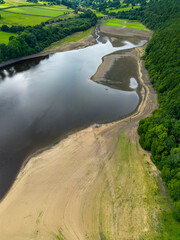 Aerial drone view of Lindley Wood Reservoir, North Yorkshire, showing the dry reservoir basin following heatwave & hot weather.