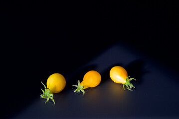 Yellow tomatoes on the kitchen table with shadow
