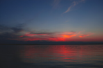 Naklejka na ściany i meble Sunset on the sea. Background image with clouds and reflection.