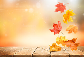 falling autumn maple leaves on wooden table with copy space