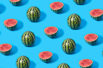 Pattern of mini watermelons and slice watermelon halves on a blue background.