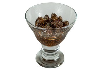 glass ramekin of jam made from pine cones on a white background