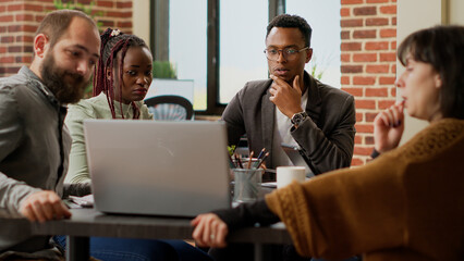 Business people doing teamwork partnership to create startup presentation, analyzing charts data information to do online research. Working with graphs statistics, coworkers meeting in boardroom.