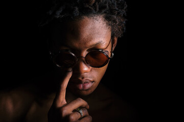 young afro american man in sunglasses on black background copy space
