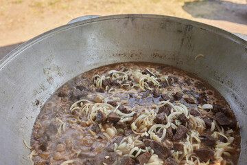 Hiking pot, Bowler in the bonfire. in cauldron at the stake. Traveling, tourism, picnic cooking,...