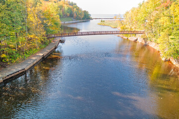Fototapeta na wymiar Aerial perspective of a wood bridge over a river leading into Lake Michigan in Upper Michigan