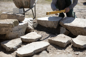 Stone Work in Front of own House of an Adult Unrecognizable Man