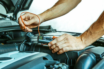 vehicle service concept photo. car engine wiring check. checking the sensors in the car motor. car electrician doing car diagnostics