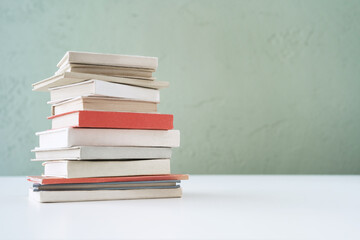 Stack of mini old books on bookshelf.