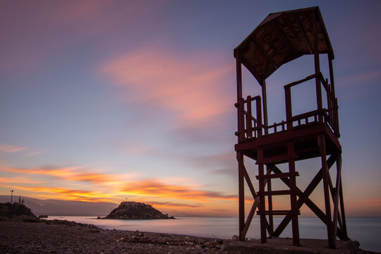 pireas greek sunrise long exposure rocks sand and island