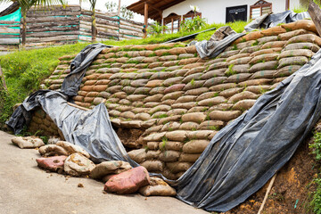 Retaining wall with sacks filled with earth to prevent landslides
