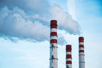 Air pollution. Smoking chimneys against blue sky.